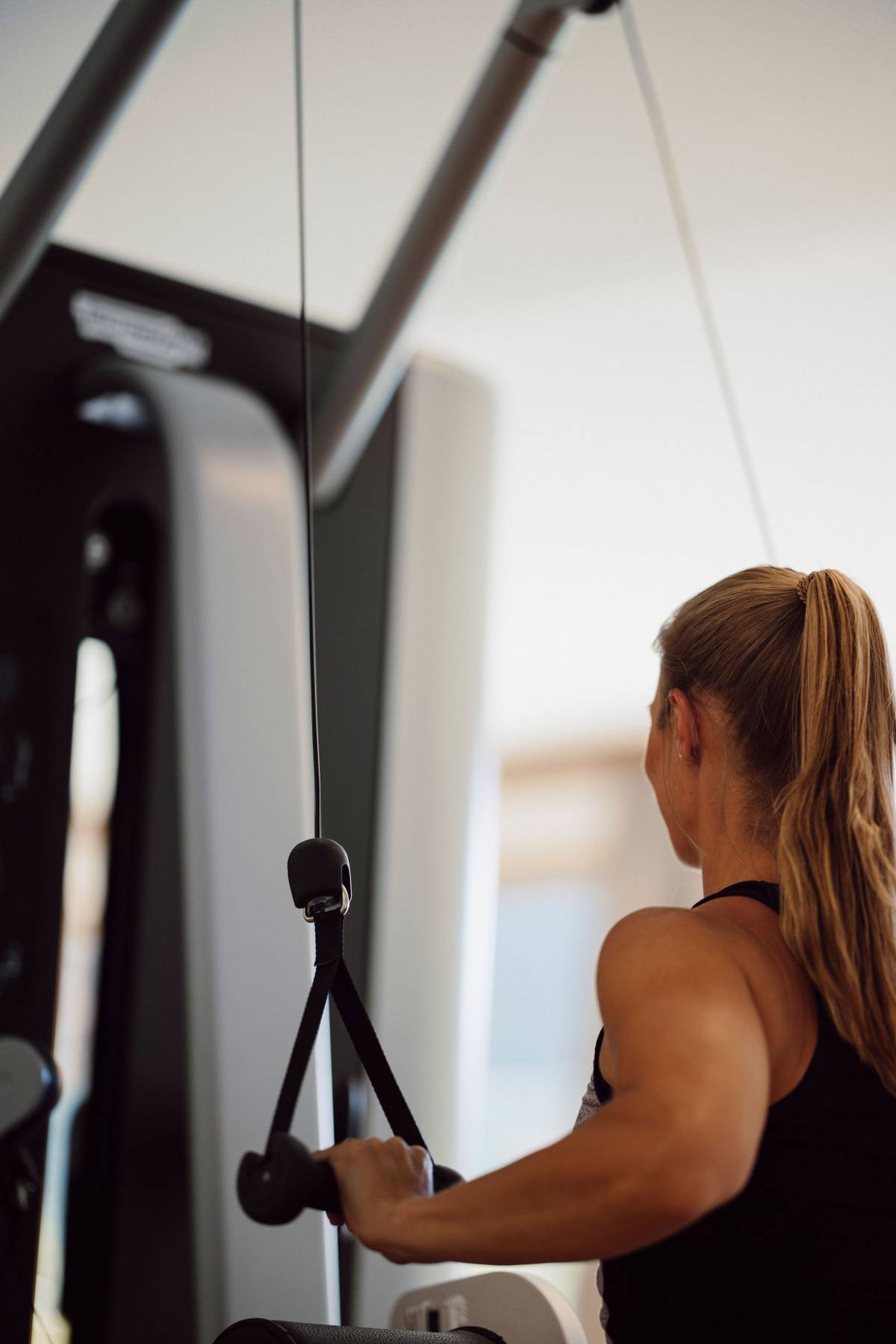 Frau trainiert an Fitnessgerät im Ferienresort Central Flachau