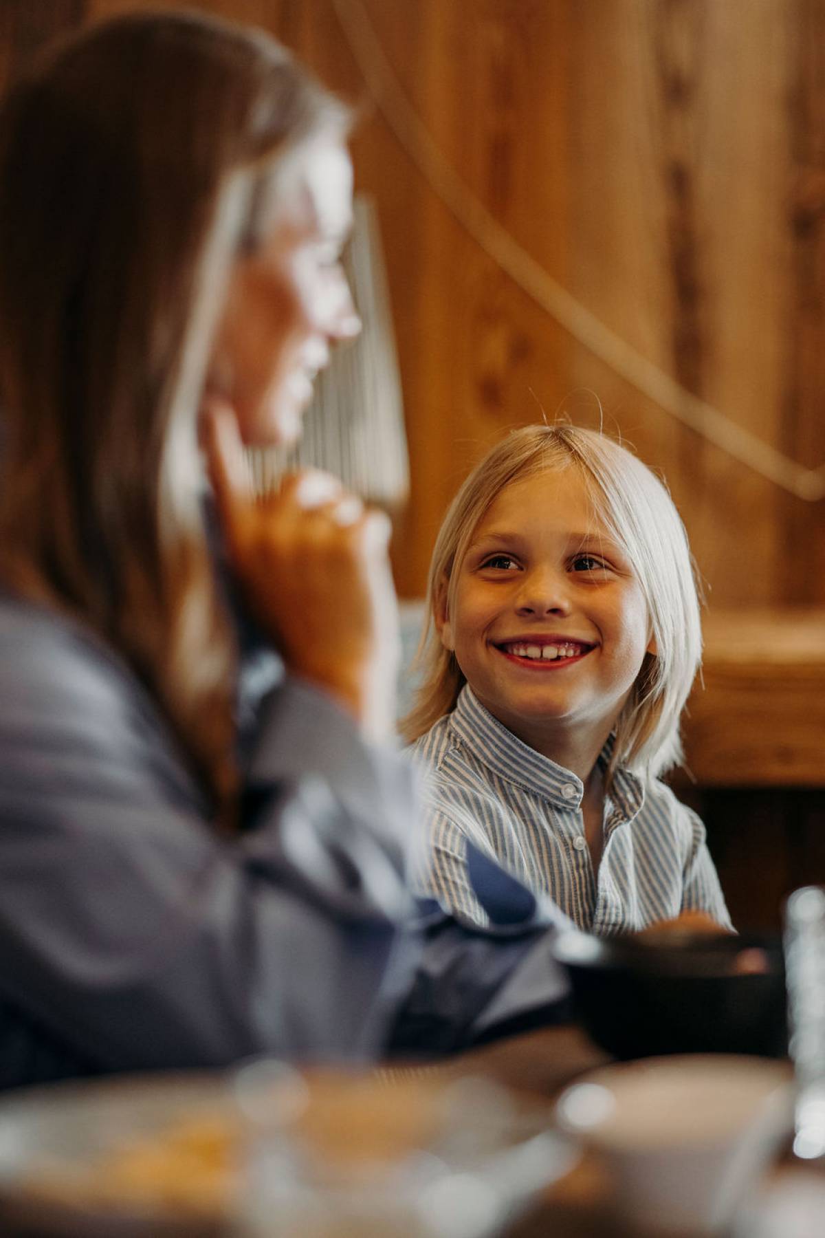 Lächelndes Kind mit Mutter am gedeckten Tisch