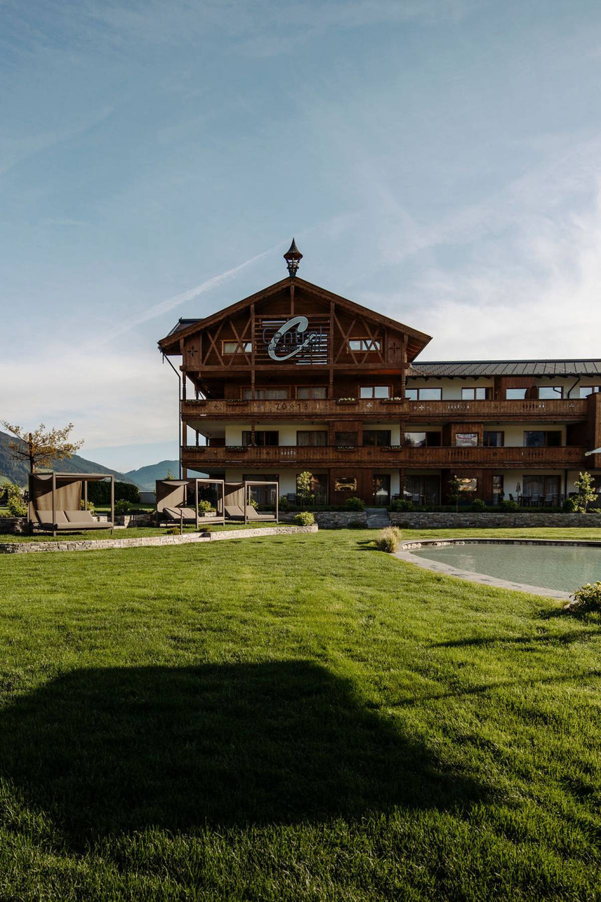 Rasen und Outdoor-Pool im Ferienresort Central Flachau