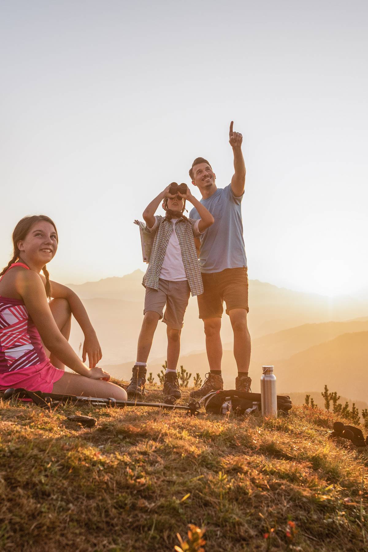 Familie beim Wandern auf dem Berggipfel bei Sonnenaufgang im Pongau