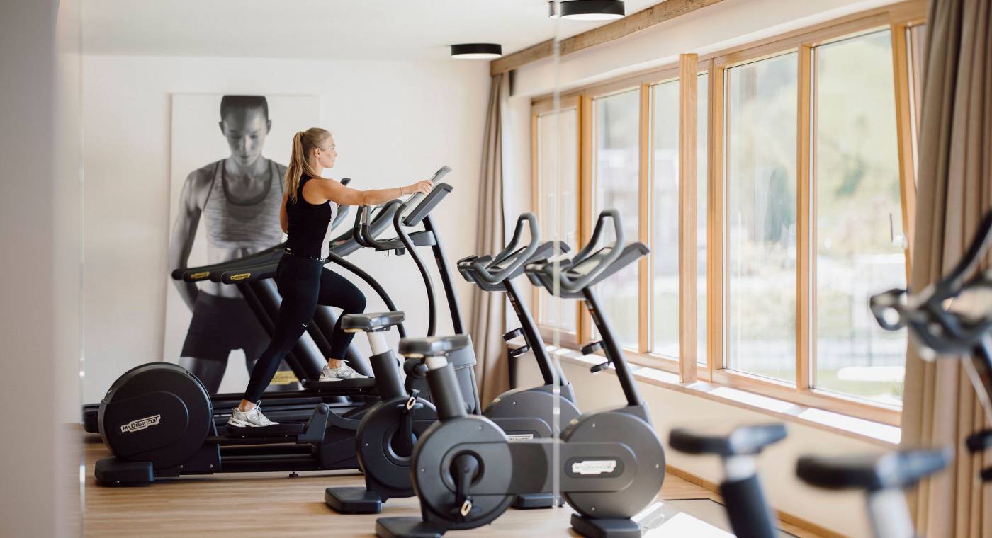 Frau auf Stepper trainiert im Fitnessraum des Ferienresort Central Flachau