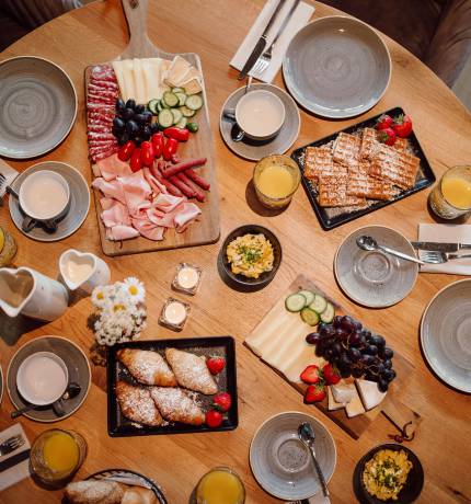 Draufsicht eines runden gedeckten Frühstückstisches im Restaurant Glückskind Ferienresort Central Flachau