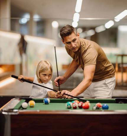 Vater und Sohn am Billardtisch im Ferienresort Central Flachau