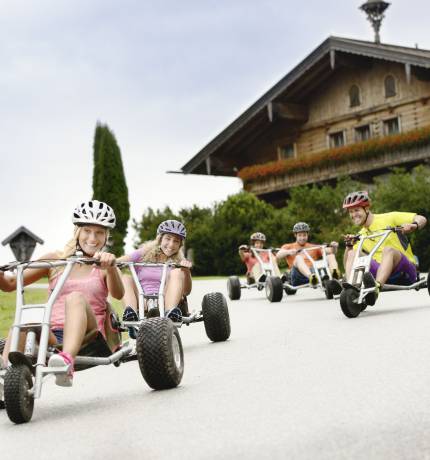 Mountain Carts fahren auf einer Straße in Flachau bergab