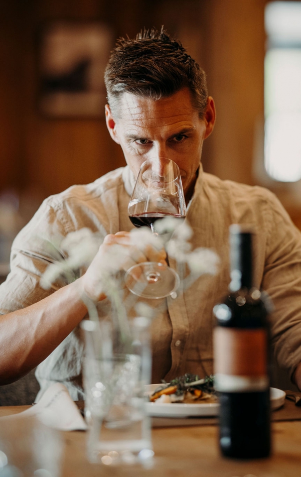 Mann im Restaurant Glückskind riecht am Rotwein im Glas