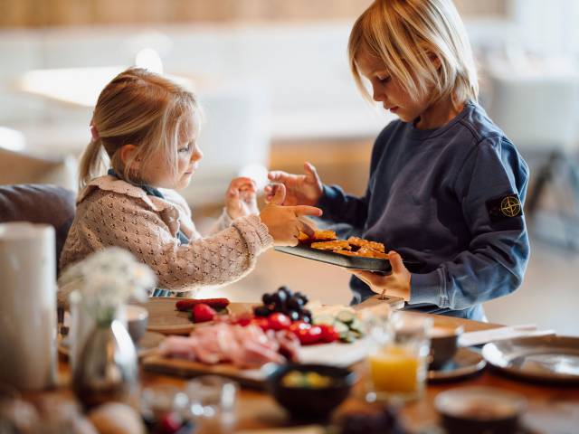 Kinder am gedeckten Tisch beim Frühstück im Ferienresort Central Flachau