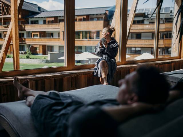 Paar in grauen Bademänteln entspannt im Ruhebereich des Ferienresort Central Flachau