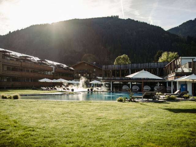 Außenbereich mit Pool, Sonnenschirmen und Liegen im Ferienresort Central Flachau