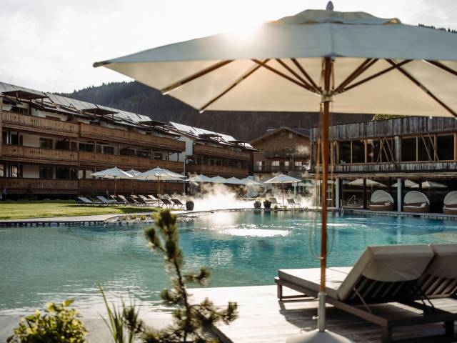 Sonnenschirme und Liegen am Schwimmteich im Ferienresort Central Flachau