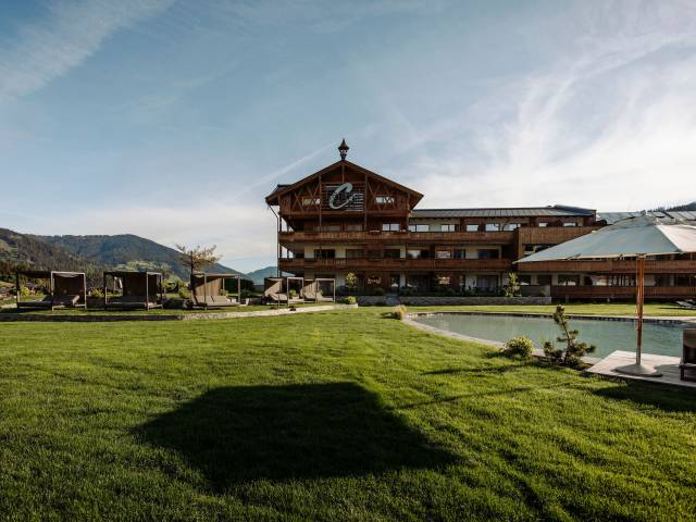 Rasen und Outdoor-Pool im Ferienresort Central Flachau