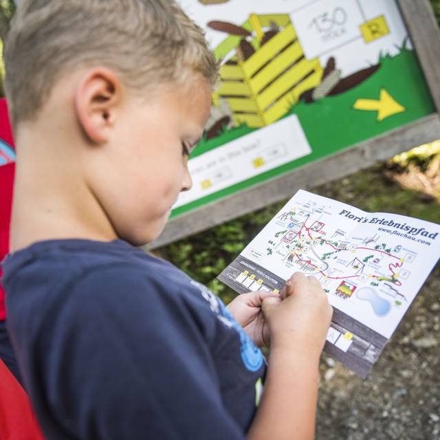 Kind mit Karte und Stift auf Floris Erlebnispfad in Flachau