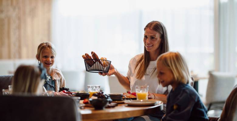 Draufsicht Familie am runden gedeckten Frühstückstisch