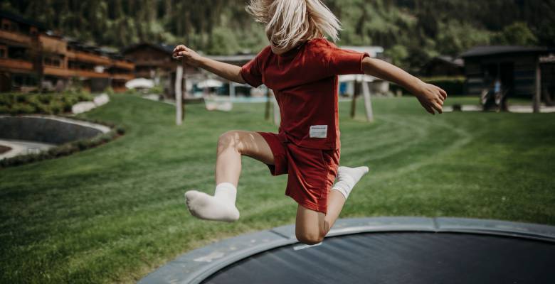 Blondes Kind fährt mit blau-schwarzem Go Kart den Berg hinunter