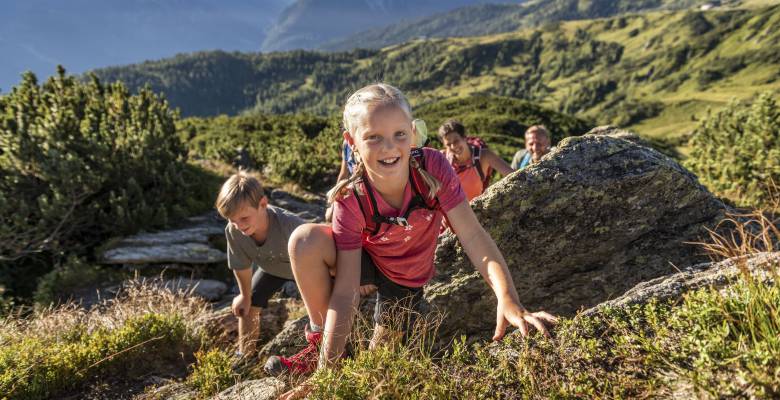 Familie im Sonnenschein an einem kleinen Bergsee im grünen Flachau