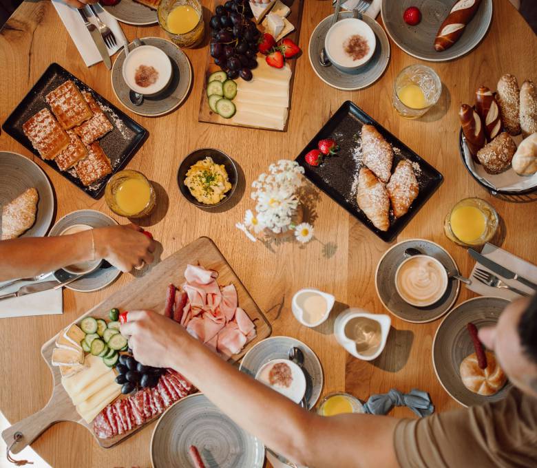 Draufsicht Familie am runden gedeckten Frühstückstisch