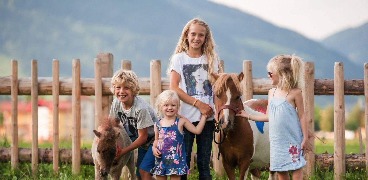 Fröhliche Kinder mit Ponys im Familienhote - Ferienanlage Central Flachau